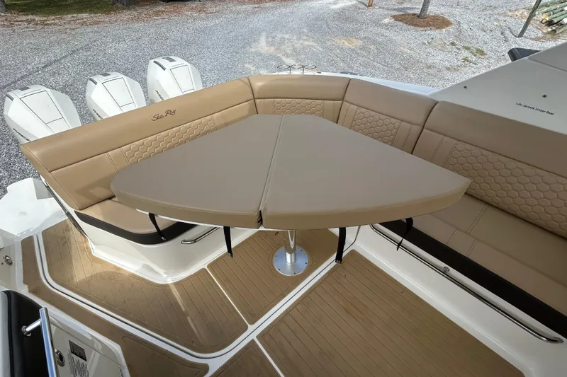 Slide: The Image of 2022 Sea Ray Sundancer 320 Outboard with tan seating and table on deck. - 10