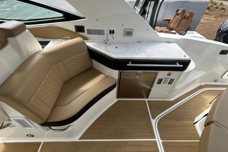 Slide: The Image of Luxurious interior of 2022 Sea Ray Sundancer 320 Outboard with tan seating and kitchenette. - 11