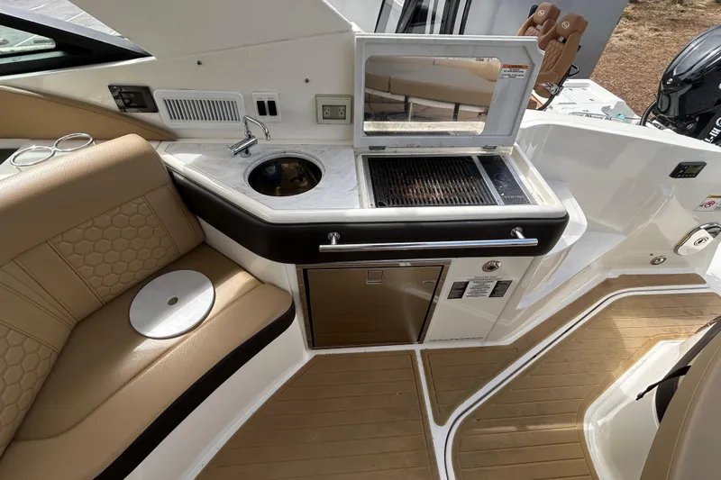 Slide: The Image of 2022 Sea Ray Sundancer 320 Outboard interior with kitchenette and seating area. - 12