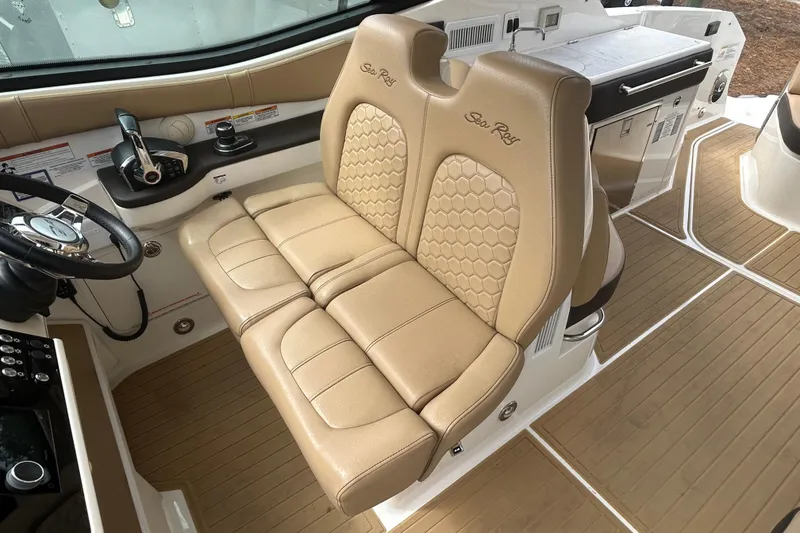Slide: The Image of 2022 Sea Ray Sundancer 320 Outboard cockpit with tan leather seating and modern controls. - 15