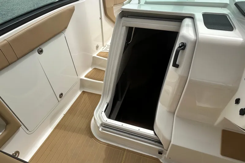 Slide: The Image of 2022 Sea Ray Sundancer 320 Outboard cabin entrance with tan seating and steps. - 18