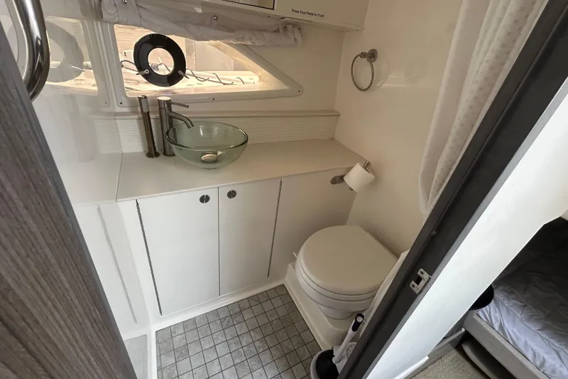 Slide: The Image of 2022 Sea Ray Sundancer 320 Outboard bathroom with modern sink and compact toilet. - 25