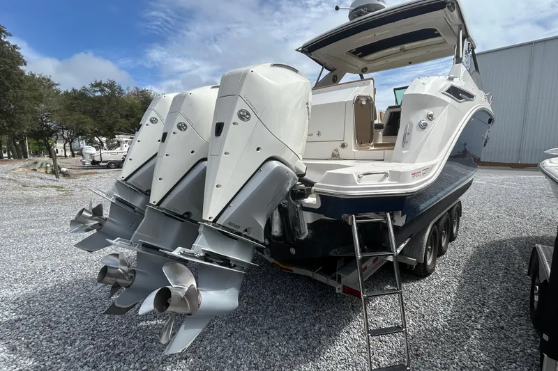 Slide: The Image of 2022 Sea Ray Sundancer 320 Outboard with triple engines on a trailer. - 3