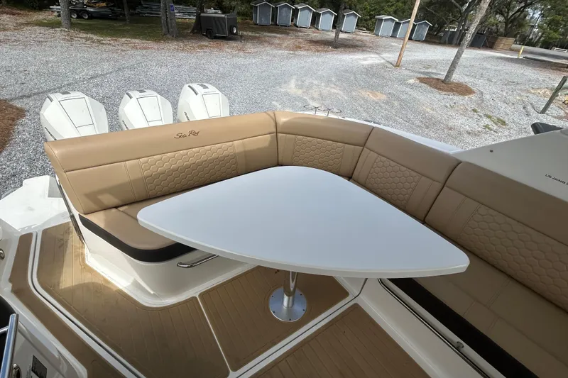 Slide: The Image of 2022 Sea Ray Sundancer 320 Outboard boat with tan seating and white table. - 9
