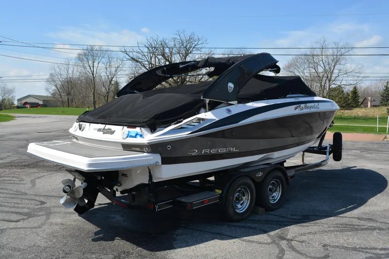 Slide: The Image of 2014 Regal 2300 Bowrider boat on trailer, parked outdoors, covered and ready for transport. - 2