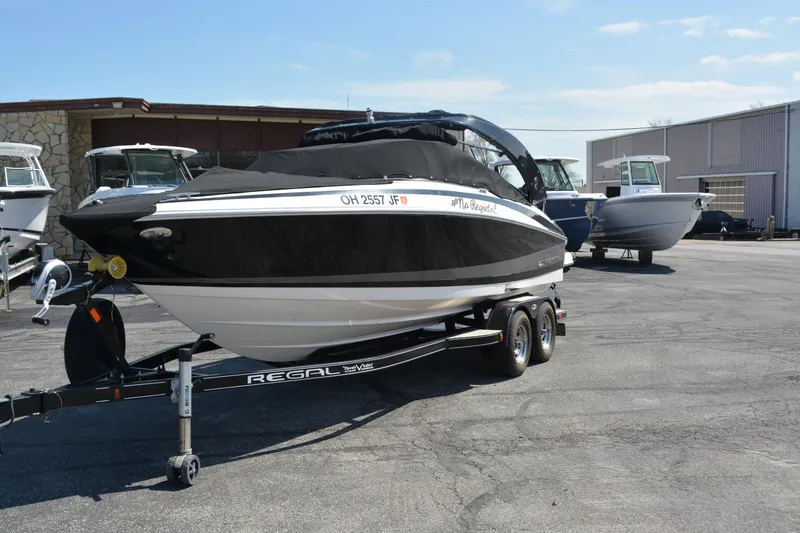 Slide: The Image of 2014 Regal 2300 Bowrider boat on trailer, parked outdoors, with protective cover. - 3