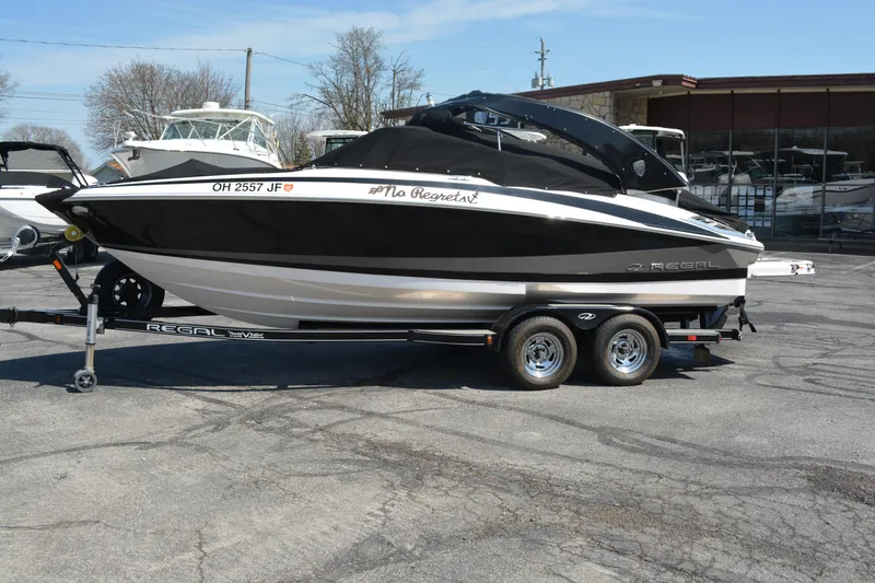 Slide: The Image of 2014 Regal 2300 Bowrider boat on trailer, black and white design, parked outdoors. - 4