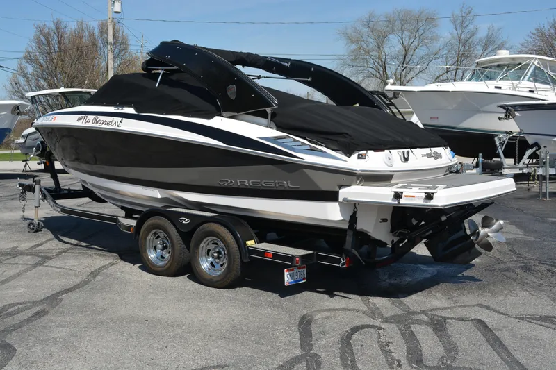 Slide: The Image of 2014 Regal 2300 Bowrider boat on trailer, covered and parked outdoors. - 5