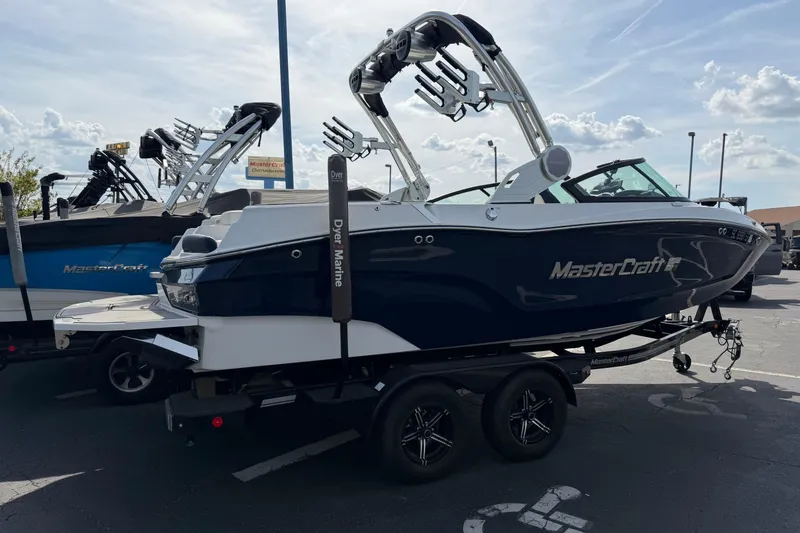 Slide: The Image of 2023 MasterCraft XT20 boat on trailer in parking lot, showcasing sleek design and modern features. - 3