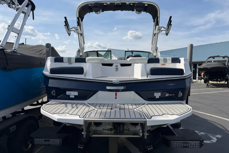 Slide: The Image of 2023 MasterCraft XT20 boat rear view at a marina under a clear sky. - 4
