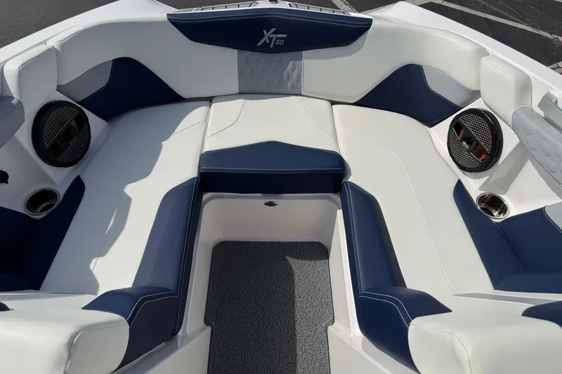 Slide: The Image of 2023 MasterCraft XT20 boat interior with blue and white seating and built-in speakers. - 7