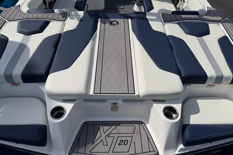 Slide: The Image of 2023 MasterCraft XT20 boat interior with blue and white cushioned seating. - 9