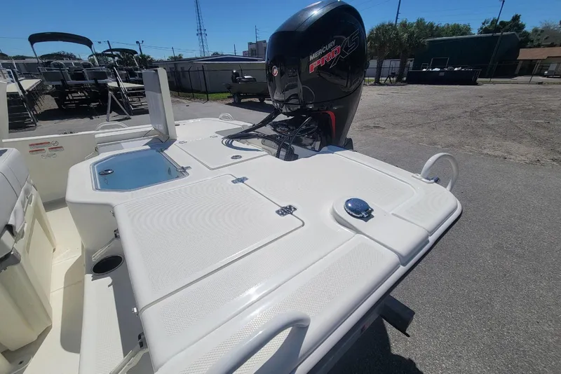 Slide: The Image of 2025 Mako Pro Skiff 19 CC boat with Mercury Pro XS engine, docked outdoors. - 14