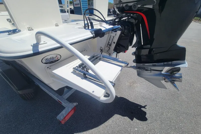 Slide: The Image of 2025 Mako Pro Skiff 19 CC boat with outboard motor and swim platform. - 15