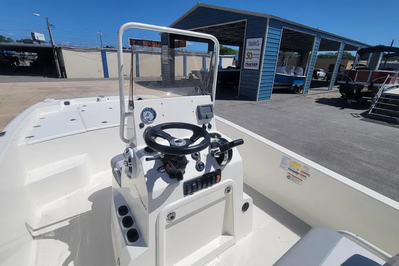 Slide: The Image of 2025 Mako Pro Skiff 19 CC boat interior with steering console and controls. - 19