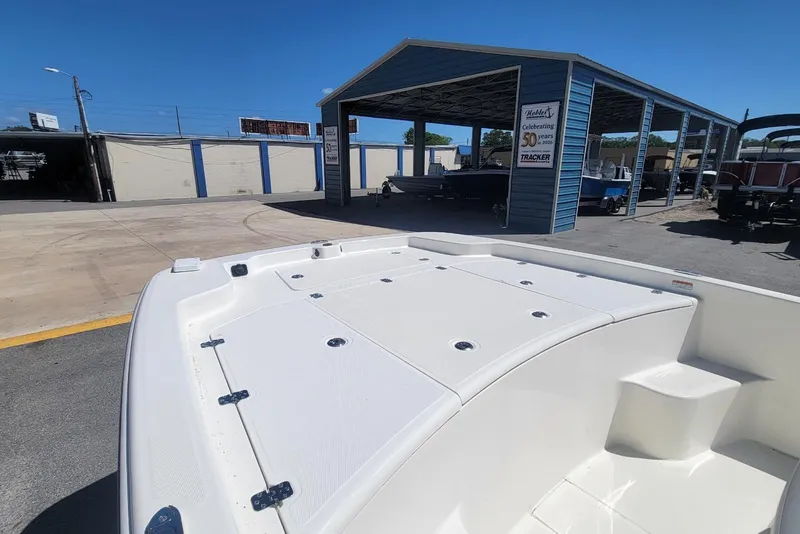 Slide: The Image of 2025 Mako Pro Skiff 19 CC boat displayed at a dealership under clear blue skies. - 8