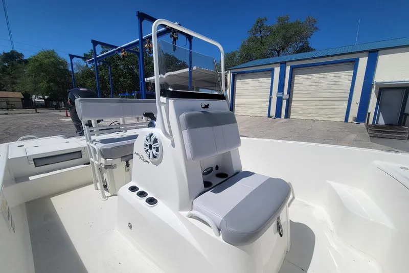 Slide: The Image of 2025 Mako Pro Skiff 19 CC boat interior with seating and console, outdoors. - 9