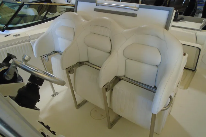 Slide: The Image of 2004 Hydra-Sports Vector 3300 CC boat interior with white cushioned seating and steering wheel. - 24