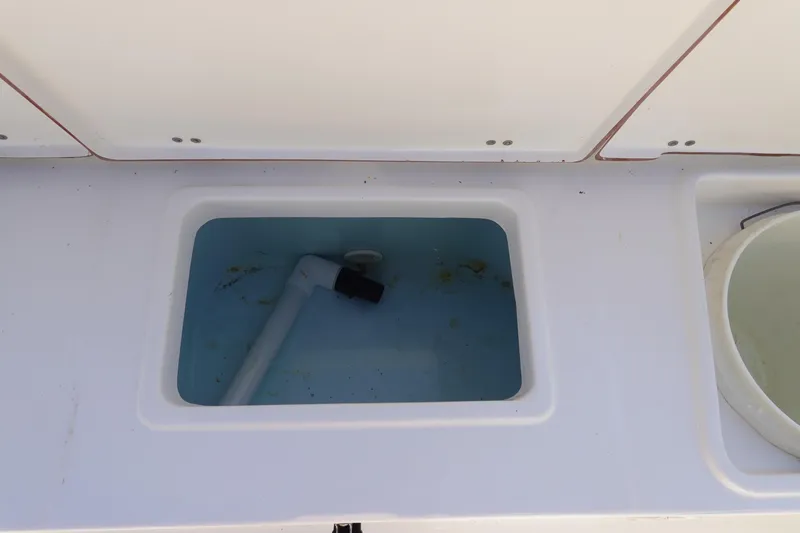Slide: The Image of Livewell compartment on a 2014 Sea Hunt Ultra 225 boat, featuring a white interior. - 10