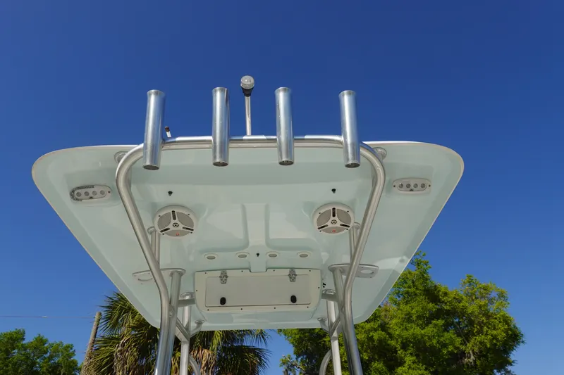 Slide: The Image of T-top of 2014 Sea Hunt Ultra 225 boat with rod holders and speakers against blue sky. - 13