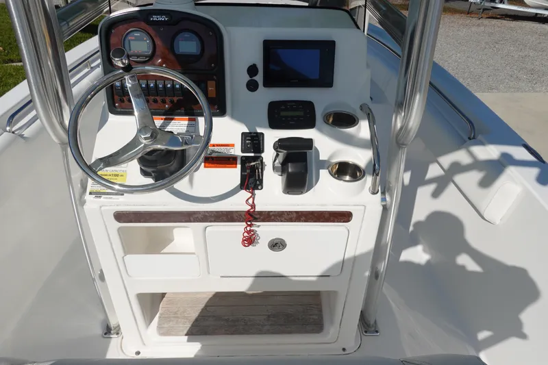 Slide: The Image of 2014 Sea Hunt Ultra 225 boat console with steering wheel and navigation controls. - 18
