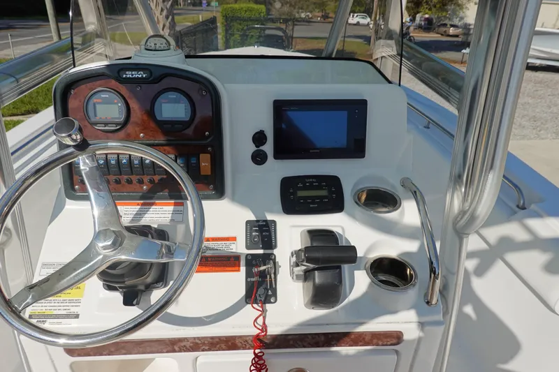 Slide: The Image of 2014 Sea Hunt Ultra 225 boat dashboard with steering wheel and navigation controls. - 19
