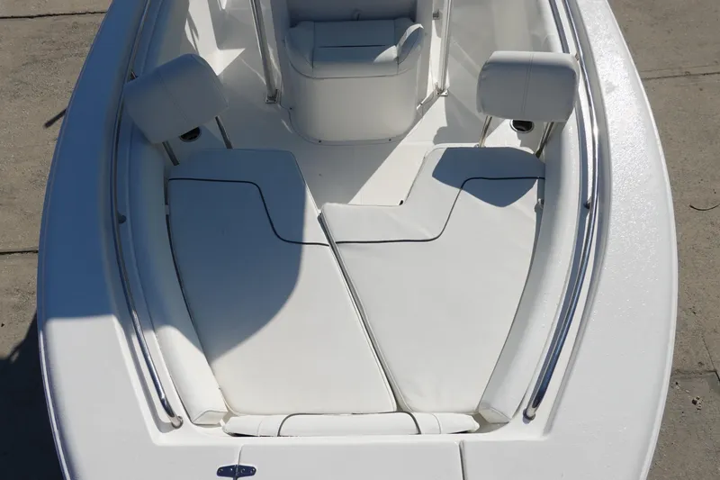 Slide: The Image of 2014 Sea Hunt Ultra 225 boat interior with white cushioned seating and stainless steel rails. - 25
