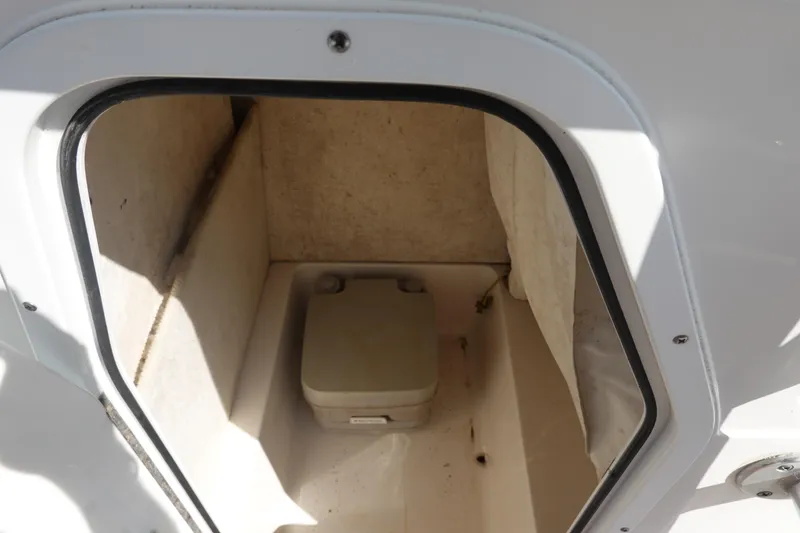 Slide: The Image of 2014 Sea Hunt Ultra 225 boat storage compartment with portable toilet. - 27