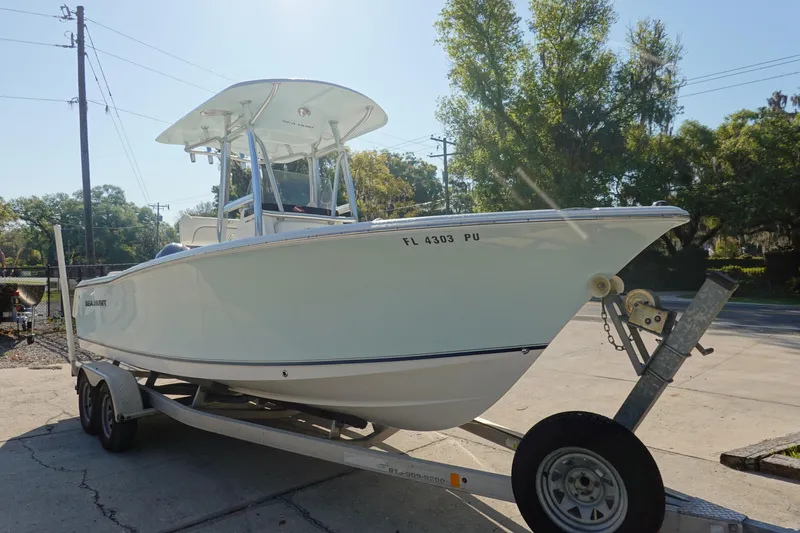 Slide: The Image of 2014 Sea Hunt Ultra 225 boat on trailer, parked outdoors under clear sky. - 3