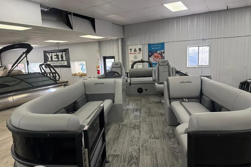 Slide: The Image of 2026 Bentley Pontoons Legacy 243 Swingback in showroom, featuring luxurious seating and modern design. - 2