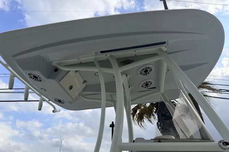 Slide: The Image of 2026 Pathfinder 2400 TRS boat T-top with speakers and rod holders against cloudy sky. - 10