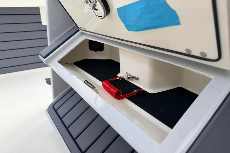 Slide: The Image of 2026 Pathfinder 2400 TRS boat compartment with red safety lanyard and blue tape. - 21