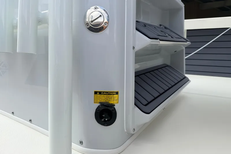 Slide: The Image of 2026 Pathfinder 2400 TRS boat detail showing storage compartments and caution label. - 23