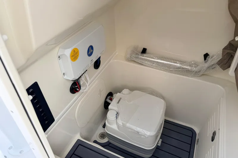 Slide: The Image of Interior of 2026 Pathfinder 2400 TRS boat featuring a compact marine toilet. - 36