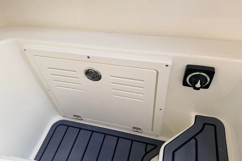 Slide: The Image of 2026 Pathfinder 2400 TRS boat interior with storage compartment and control knob. - 39