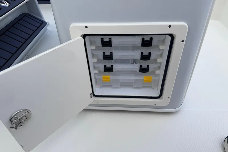 Slide: The Image of Open storage compartment on 2026 Pathfinder 2400 TRS boat, featuring organized tackle boxes. - 48