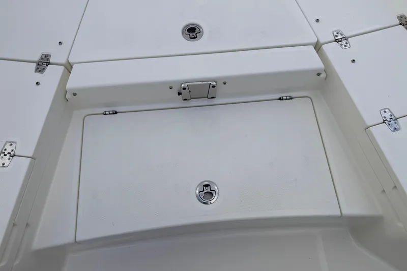 Slide: The Image of 2026 Pathfinder 2400 TRS boat storage compartments with secure latches and hinges. - 52