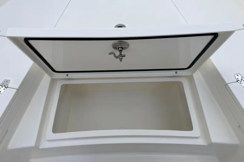 Slide: The Image of Open storage compartment on 2026 Pathfinder 2400 TRS boat, featuring a secure latch. - 53