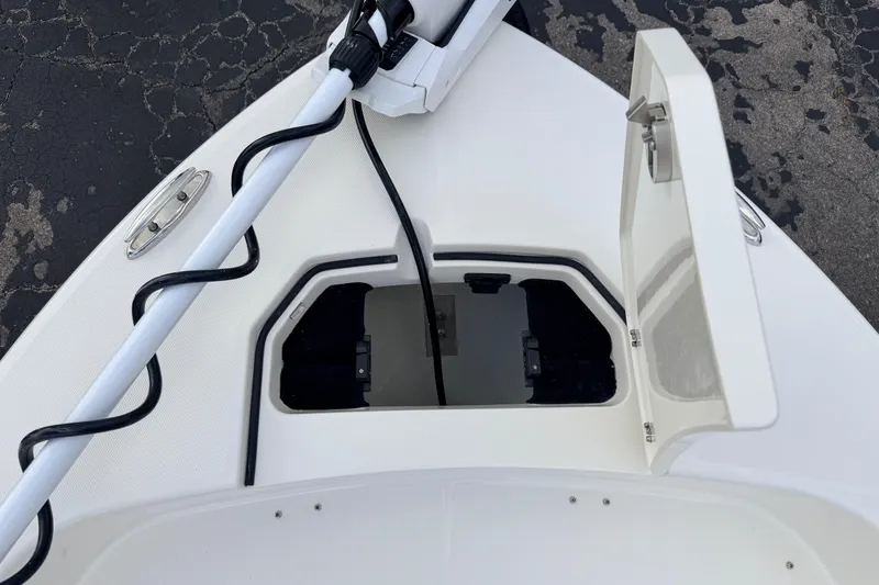 Slide: The Image of Bow storage compartment on a 2026 Pathfinder 2400 TRS boat, featuring a trolling motor. - 59