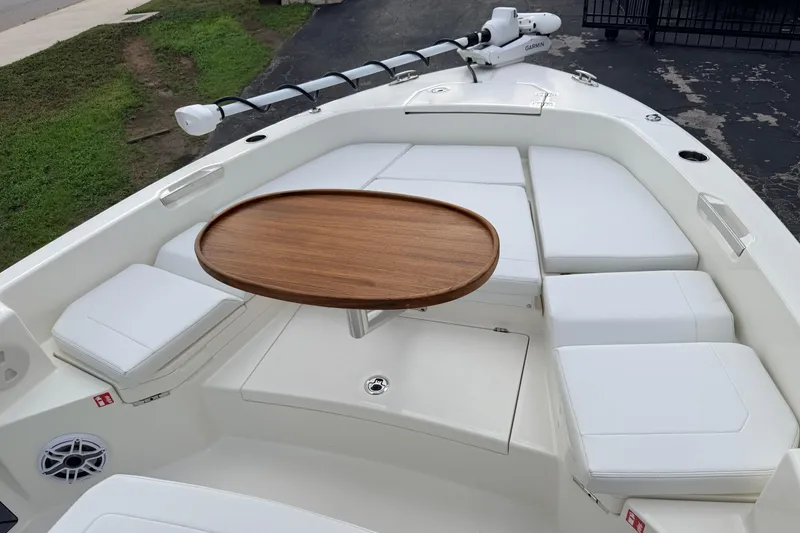 Slide: The Image of 2026 Pathfinder 2400 TRS boat interior with cushioned seating and wooden table. - 65
