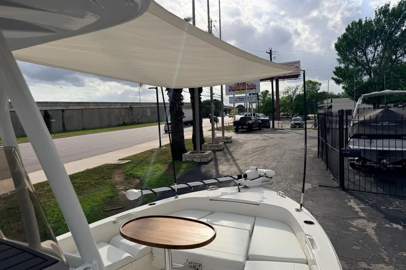 Slide: The Image of 2026 Pathfinder 2400 TRS boat with canopy and seating, parked near a road. - 67