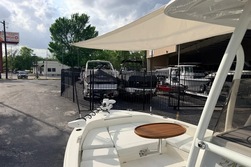 Slide: The Image of 2026 Pathfinder 2400 TRS boat displayed outdoors at a dealership with other boats. - 68