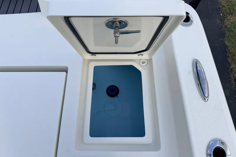Slide: The Image of Open storage compartment on 2026 Pathfinder 2400 TRS boat, featuring a blue interior. - 79