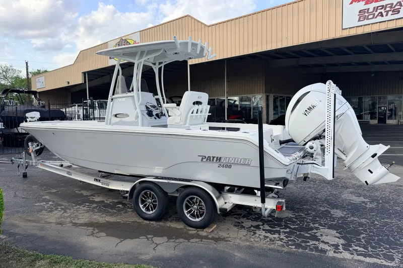 Slide: The Image of 2026 Pathfinder 2400 TRS boat on trailer outside dealership, featuring Yamaha engine. - 83