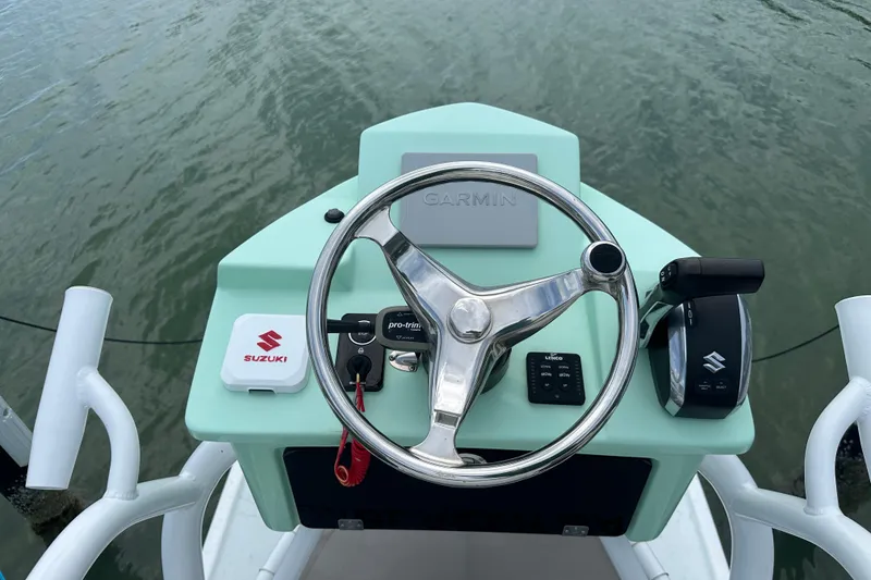 Slide: The Image of Steering console of 2023 Blazer Bay 2400 boat with Suzuki controls on water. - 10