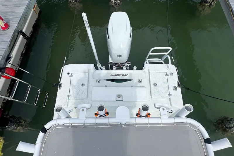 Slide: The Image of Overhead view of 2023 Blazer Bay 2400 boat docked, showcasing motor and deck features. - 13