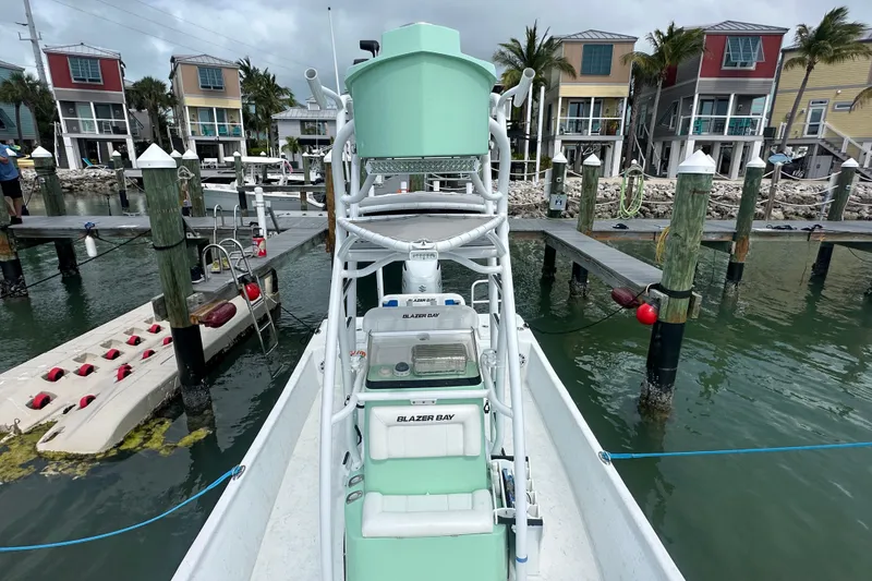 Slide: The Image of 2023 Blazer Bay 2400 boat docked at marina with colorful waterfront houses. - 16