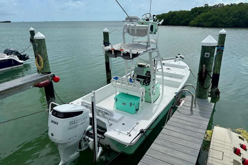 Slide: The Image of 2023 Blazer Bay 2400 boat docked with Suzuki 300 engine in scenic marina. - 24