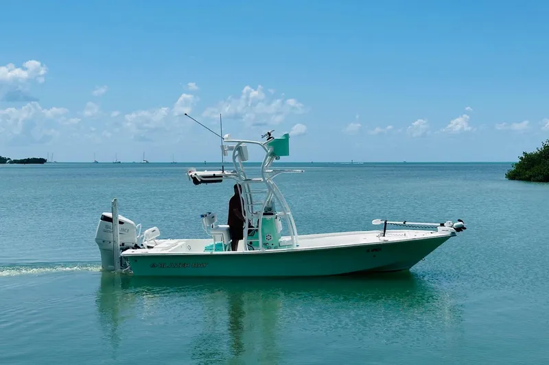 Slide: The Image of 2023 Blazer Bay 2400 boat cruising on calm blue waters under a clear sky. - 25