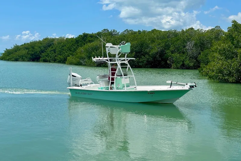Slide: The Image of 2023 Blazer Bay 2400 boat cruising in serene, green waters near lush mangroves. - 26